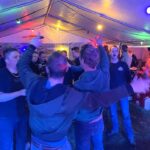 Feestvierders in feesttent bij Band Wat Oars.